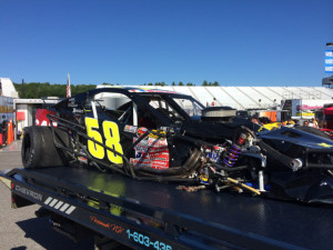Eric Goodale's wrecked Whelen Modified Tour car is brought back to the pits at New Hampshire Motor Speedway Friday after a hard practice crash