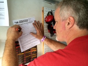 Seven-time SK Modified division champion Dennis Gada fills out a driver registration form just before the start of feature racing Saturday at the New London-Waterford Speedbowl 